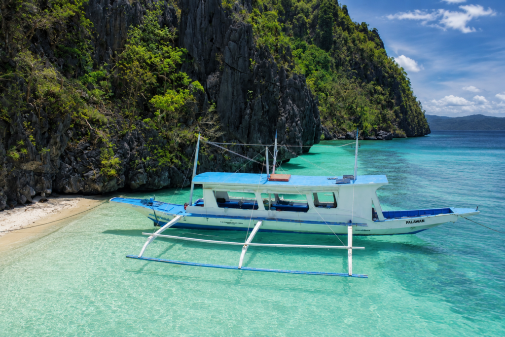El Nido group tour boat cruising through Bacuit Bay during island hopping tour